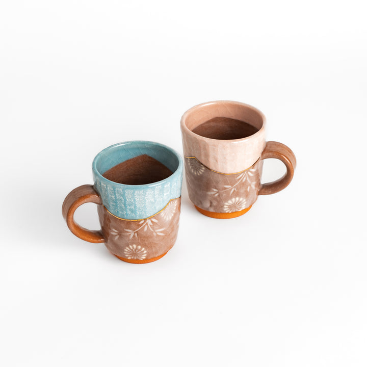 Two floral mugs with soft pink and blue hues, featuring delicate flower patterns and gold detailing, perfect for hot beverages.