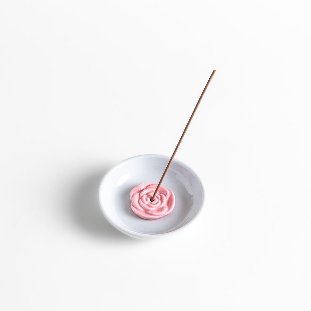 White ceramic incense holder featuring a delicate pink rose-shaped holder, adding an elegant floral touch to incense rituals while enhancing any serene or decorative space.