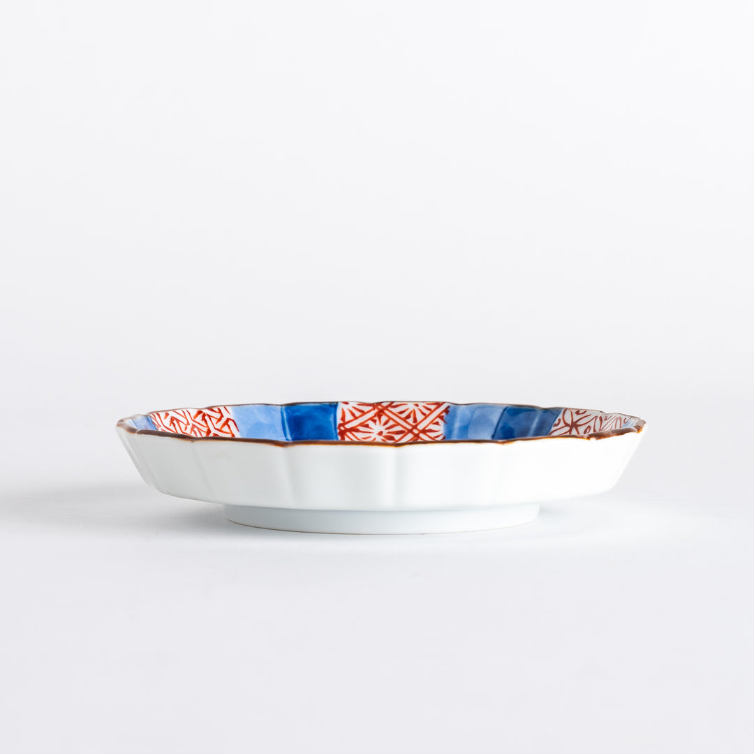 A round plate featuring a bold swirl pattern in red and blue with intricate geometric designs.