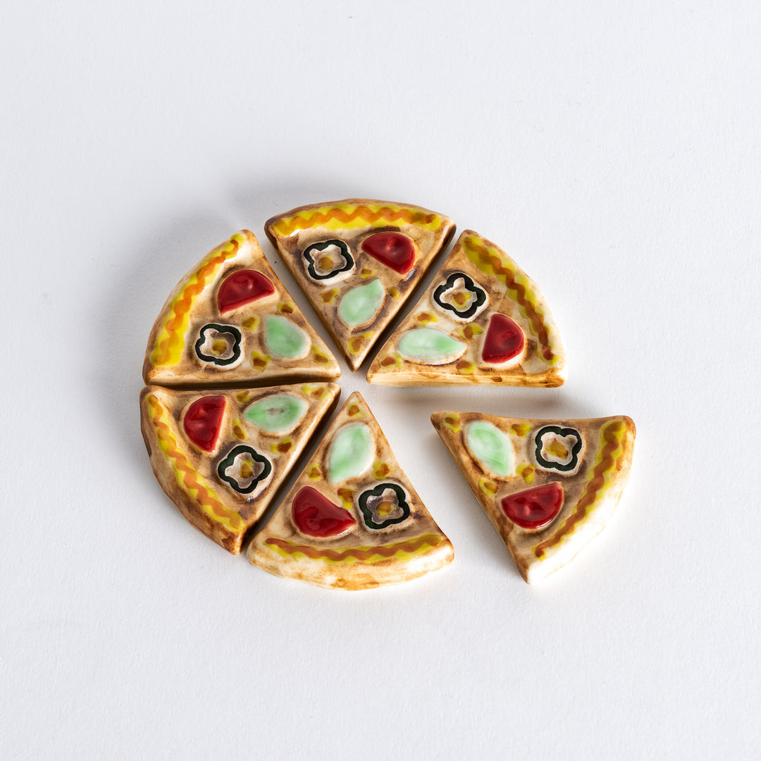 Six pizza-shaped chopstick rests arranged in a circular pattern, resembling a whole pizza, with each piece placed evenly around.