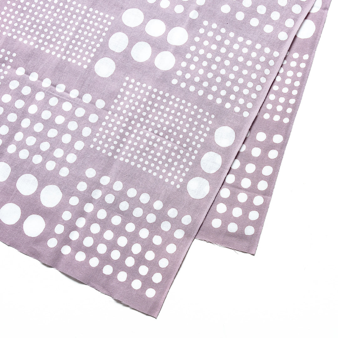 Close-up of purple gray tenugui hand towel featuring its white polka dot design in geometric squares.