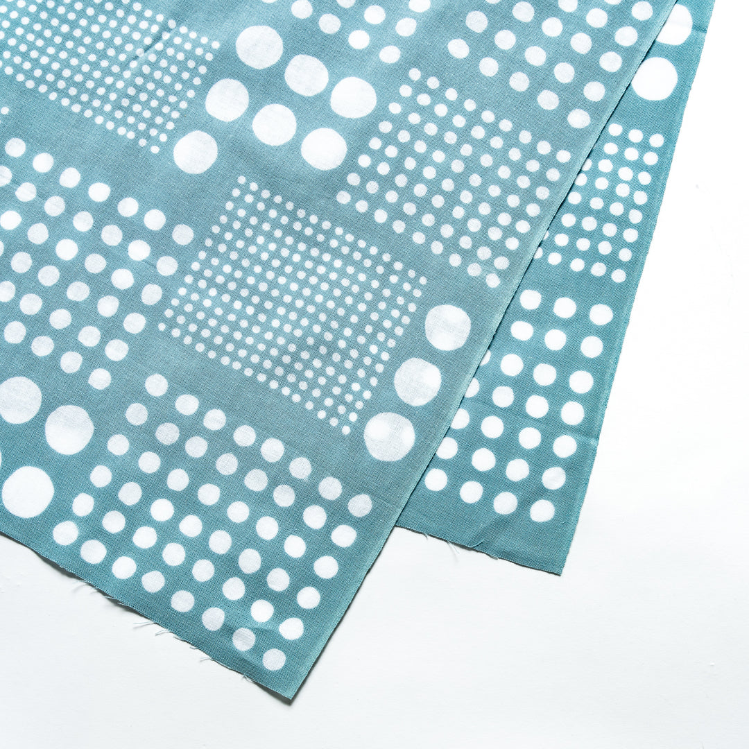 Close-up of blue tenugui hand towel highlighting its white polka dot pattern in uniform squares.