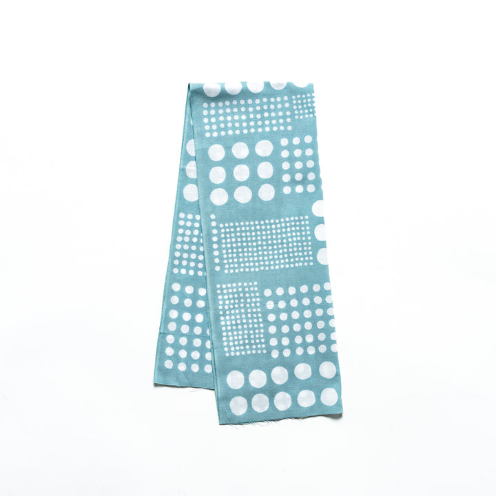 Polka dot tenugui hand towel in blue with white dots, folded neatly against a plain background.