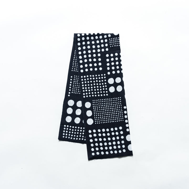 Polka dot tenugui hand towel in navy blue with white dots, folded neatly against a plain background.