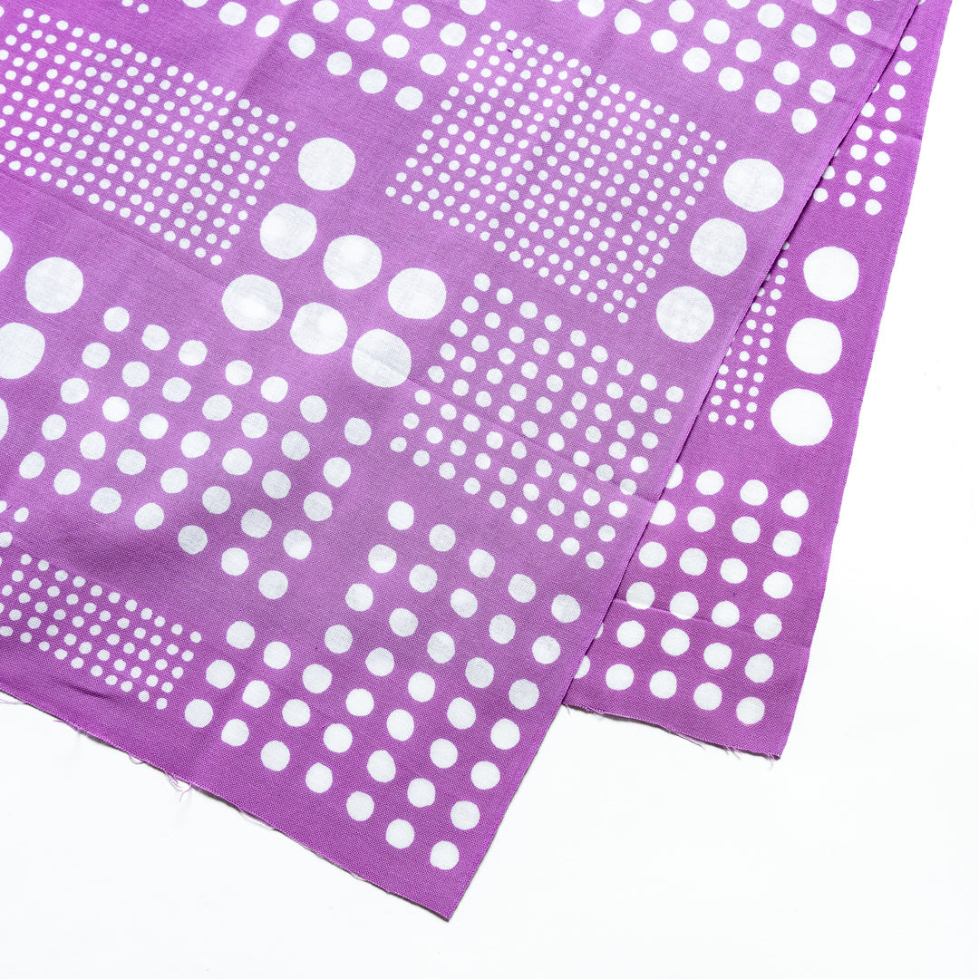 Close-up of purple tenugui hand towel highlighting the vibrant white polka dot design.