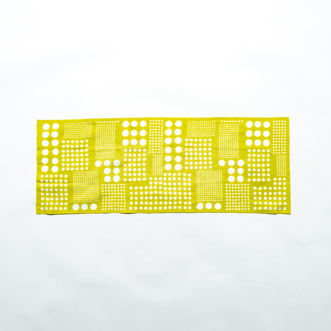 Yellow green polka dot tenugui hand towel laid flat, showcasing the crisp white dot design.