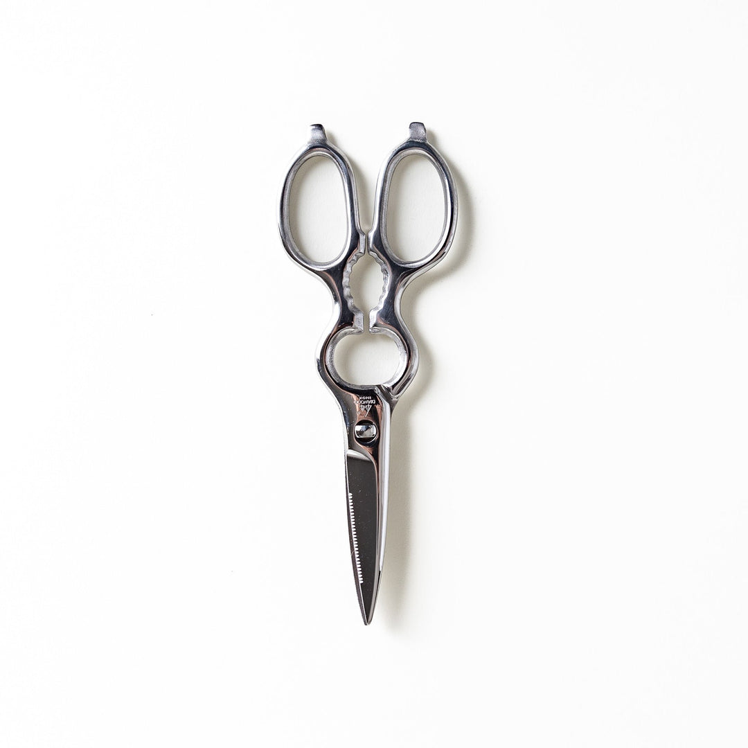 Silver kitchen shears with a sleek design, featuring a detachable mechanism and serrated blades for versatile cutting and easy cleaning.