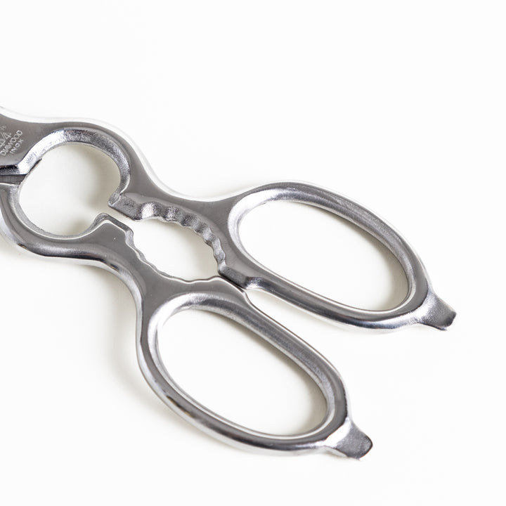 Close-up of the ergonomic silver handle on kitchen shears, featuring a smooth finish for a secure and comfortable grip.