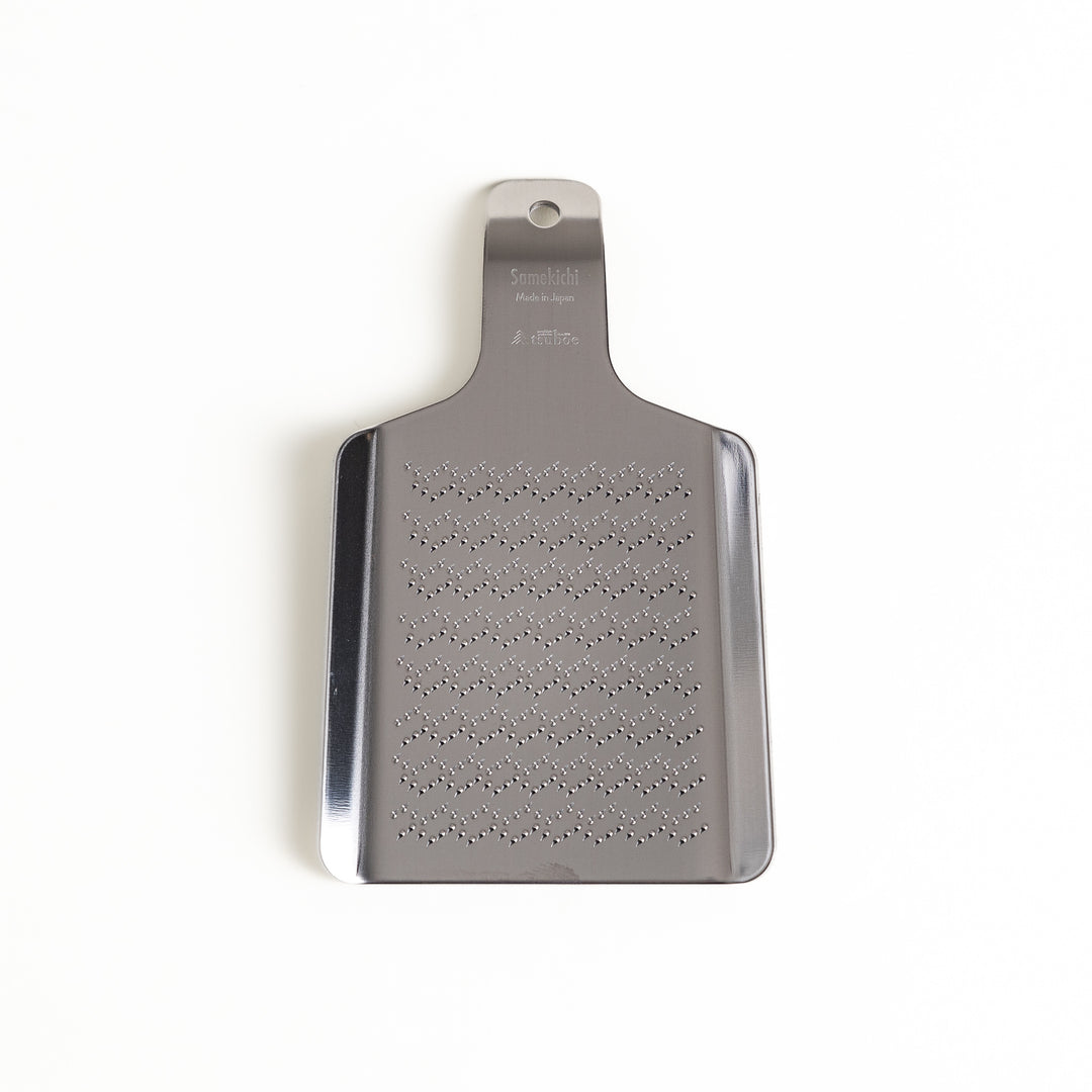 Stainless steel wasabi grater with a unique wave pattern, a specialized kitchenware tool for finely grating fresh wasabi root.