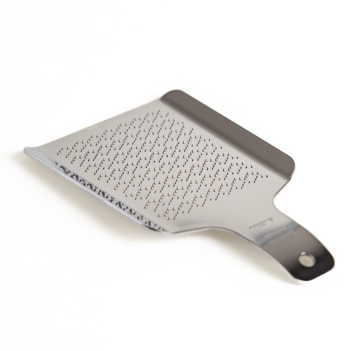 Stainless steel wasabi grater with a unique wave pattern, a specialized kitchenware tool for finely grating fresh wasabi root.