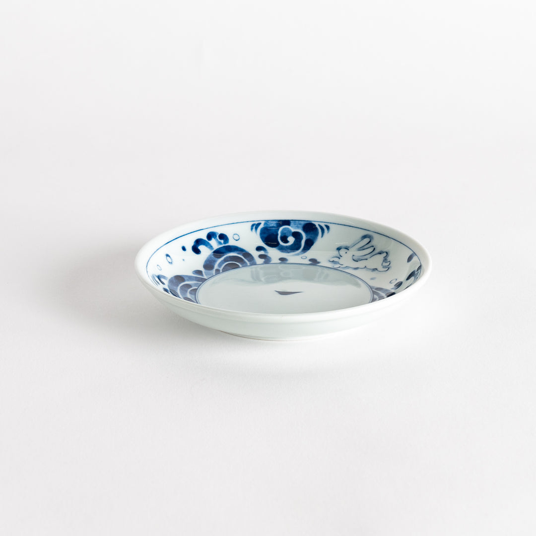 A dessert plate featuring blue waves and a rabbit motif on a white background.