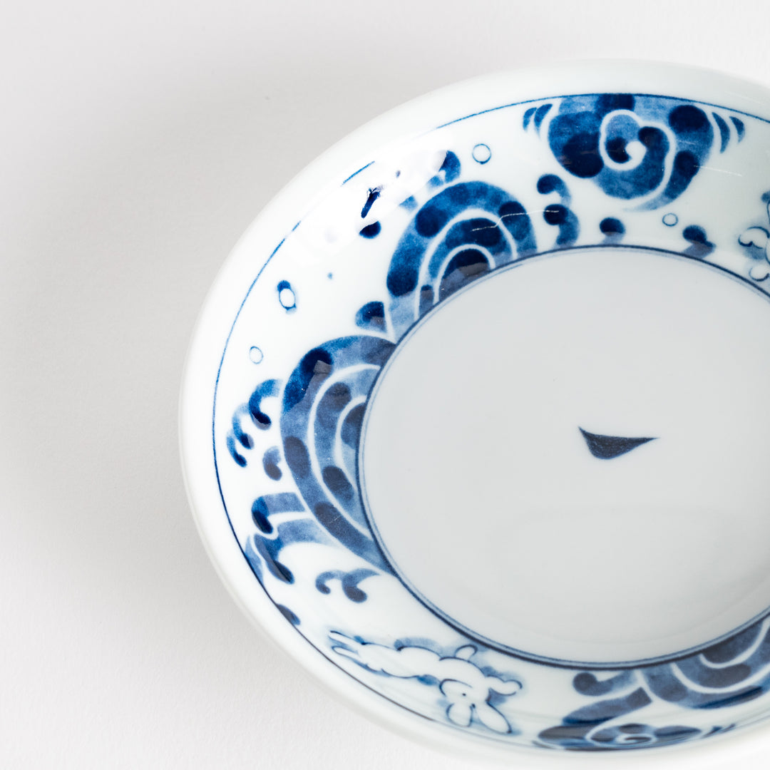 A dessert plate featuring blue waves and a rabbit motif on a white background.