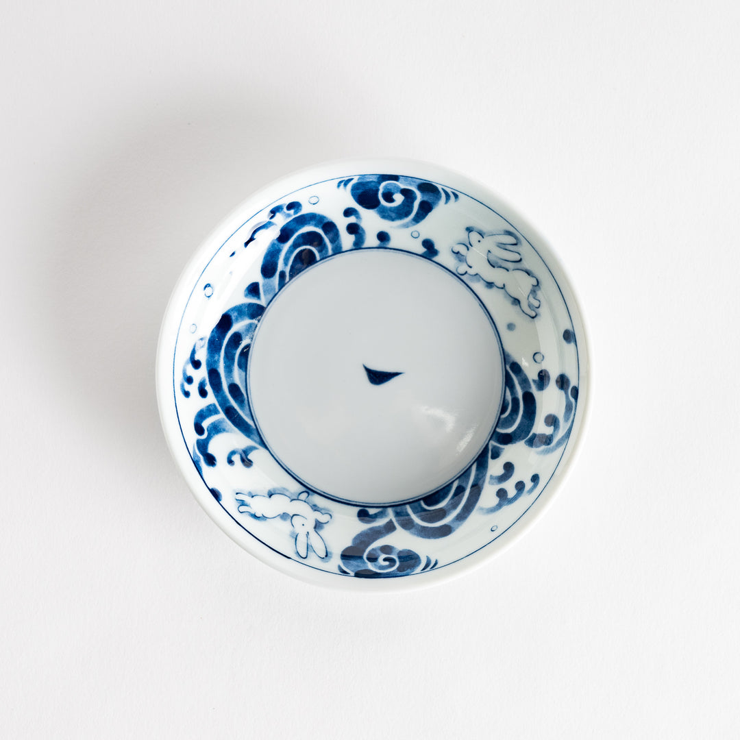 A dessert plate featuring blue waves and a rabbit motif on a white background.