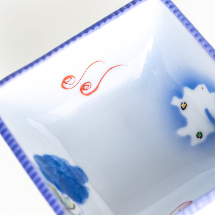 A square bowl featuring a rabbit and snowflake with a light blue rim.