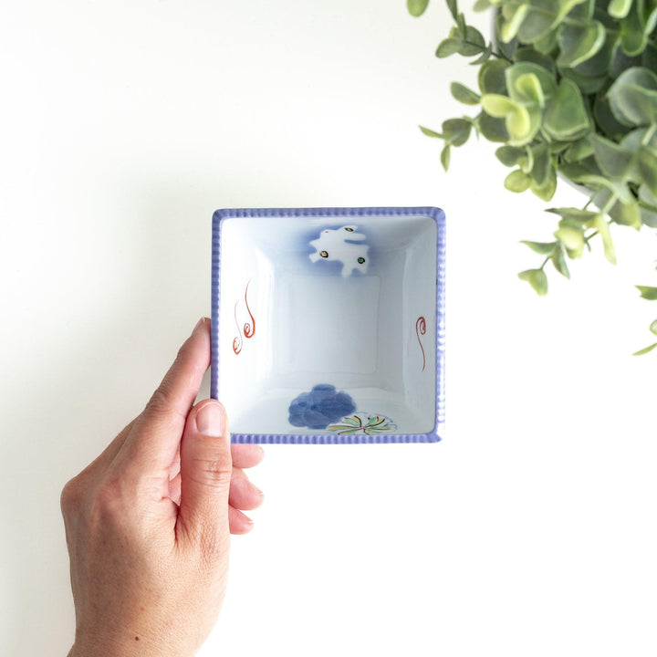 A square bowl featuring a rabbit and snowflake with a light blue rim.