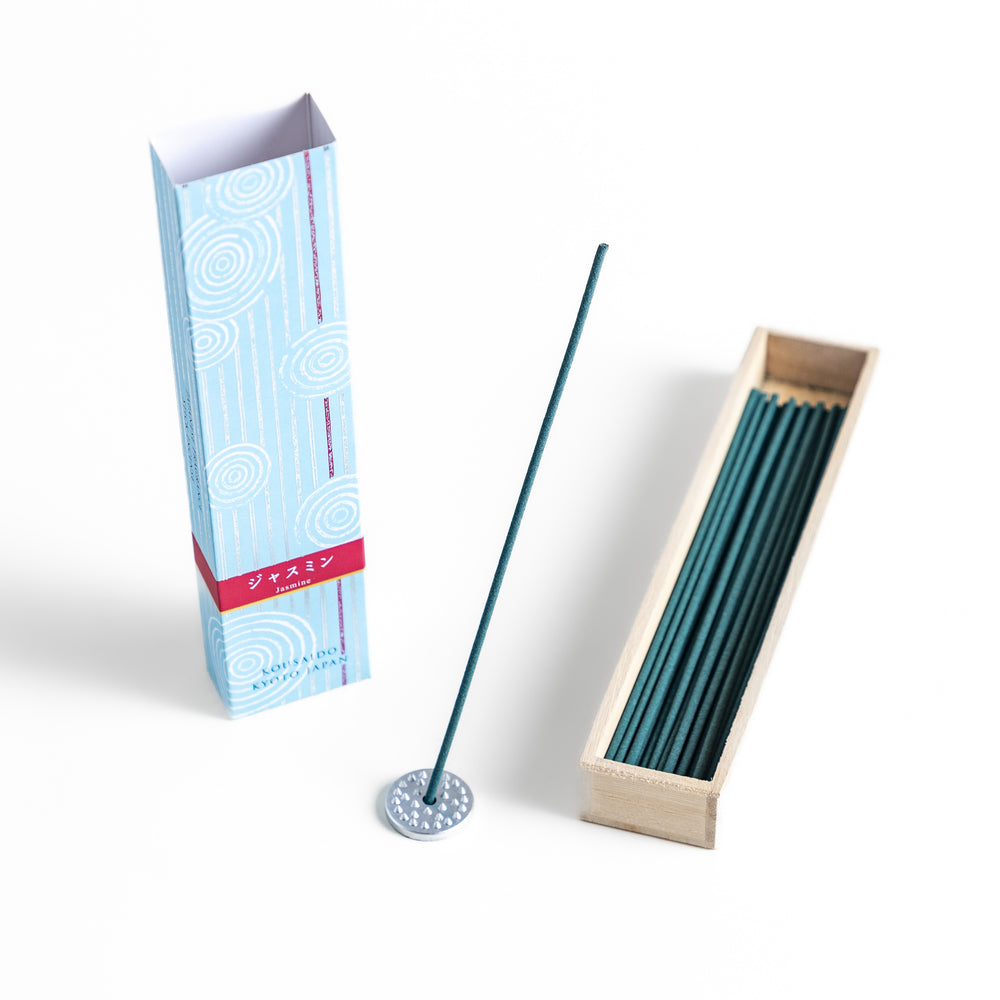 Radiant Jasmine Incense in a light wooden box with deep teal sticks, elegantly packaged in a soft blue design featuring white circular patterns for a fresh and floral ambiance.