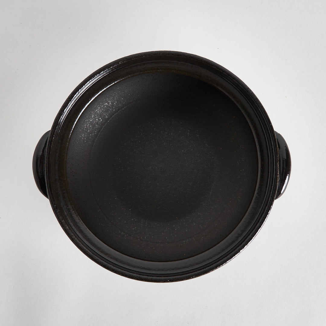 A top-down view of the donabe's black interior, showing its smooth and simple design.