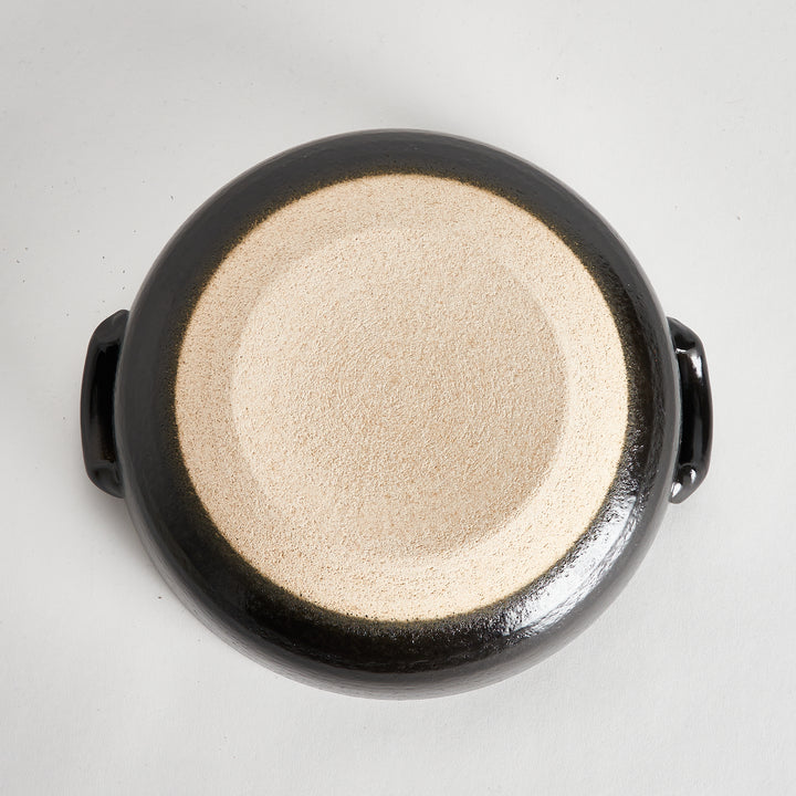 Bottom view of the donabe, showing its unglazed textured base with a smooth black edge for a natural finish.