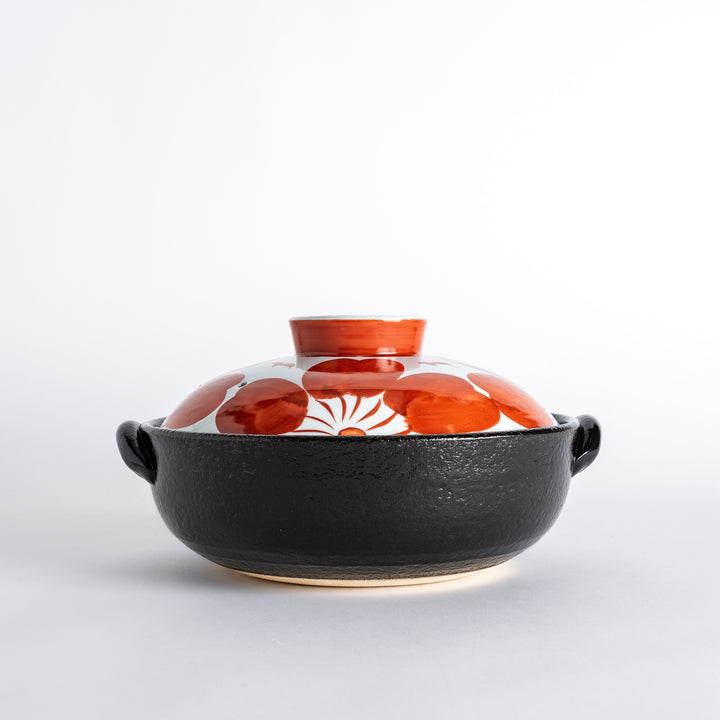 Side profile of the donabe, highlighting its sturdy black base and vibrant floral lid, a striking piece for your table.