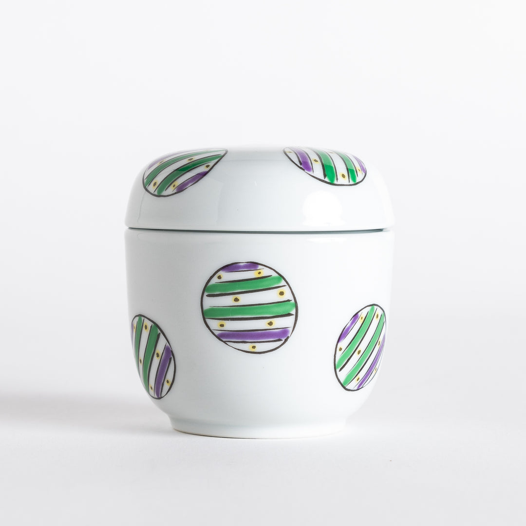 White bowl with a colorful pattern of alternating green and purple striped circles on the exterior.