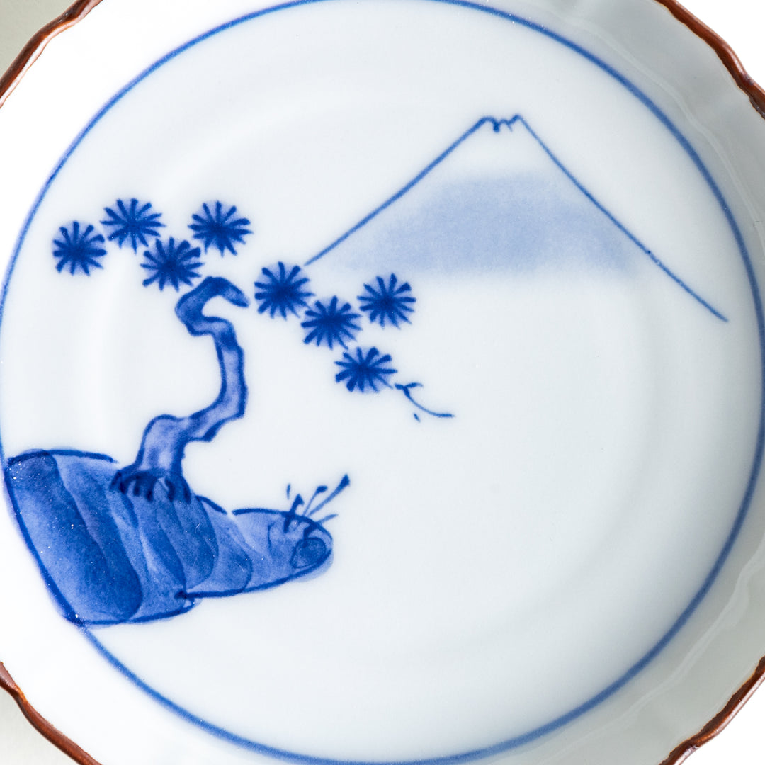 Close-up of the blue Mount Fuji and pine tree motif on the sauce dish, emphasizing the intricate details on the white porcelain.