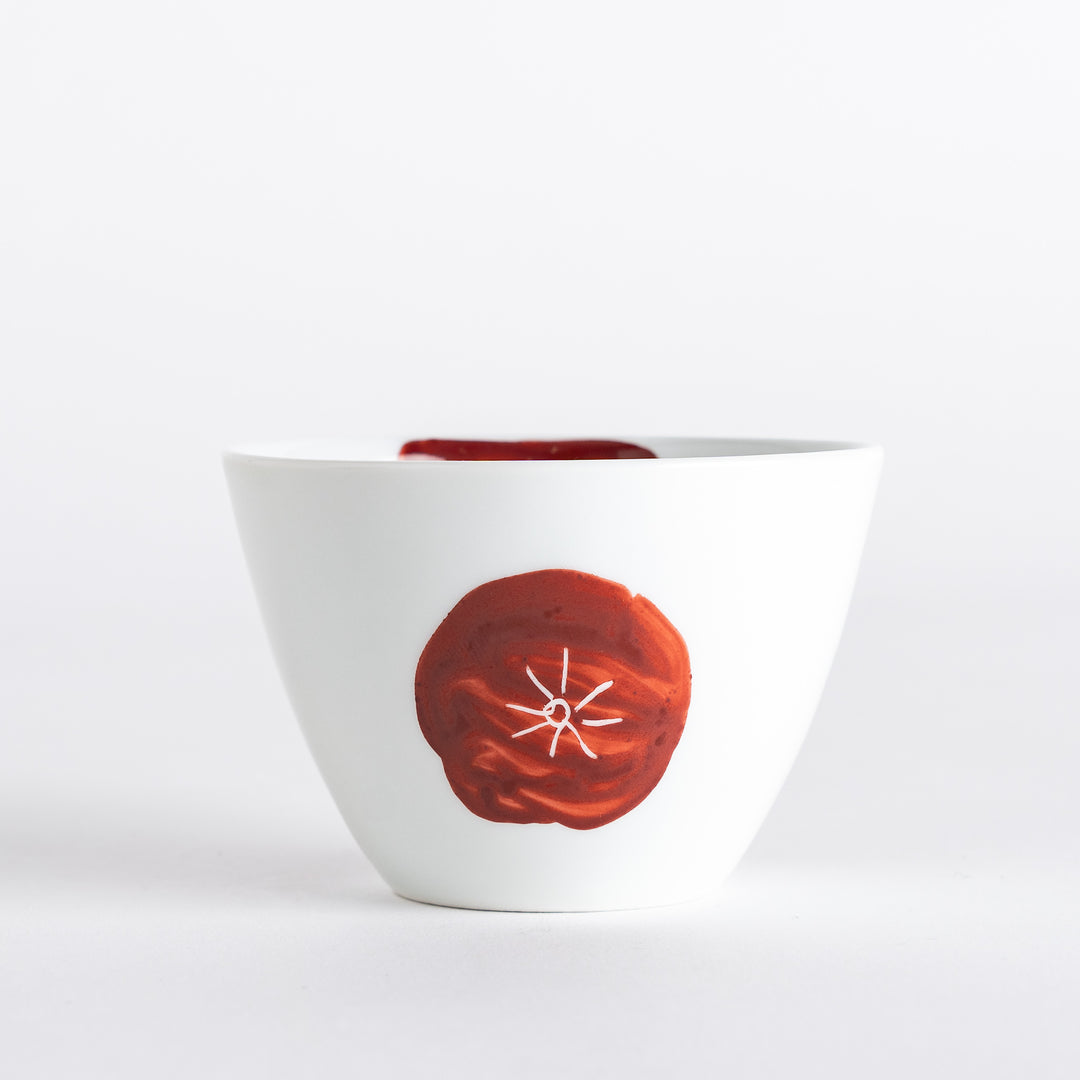 Close-up of the white teacup with red accents, emphasizing the artistic design and elegant form.