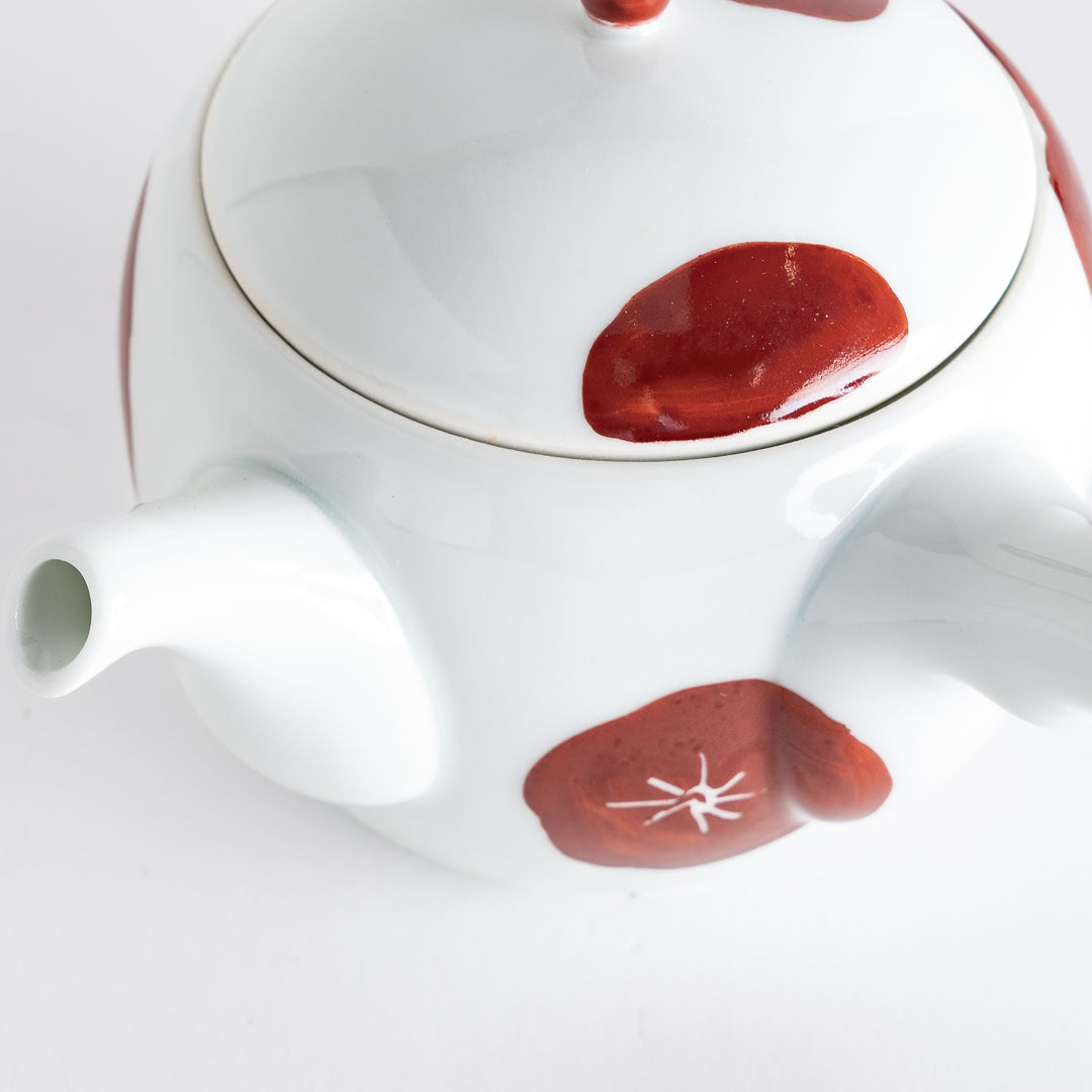 Close-up of the teapot's spout and lid, emphasizing the artistic red detailing and overall craftsmanship.