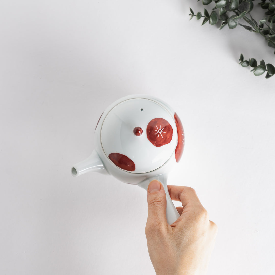 Handheld view of the teapot, highlighting the beautiful red design and smooth finish for a contemporary touch.