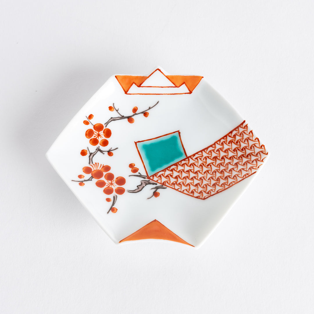 A small porcelain dish with red plum blossoms and geometric patterns, inspired by origami shapes.