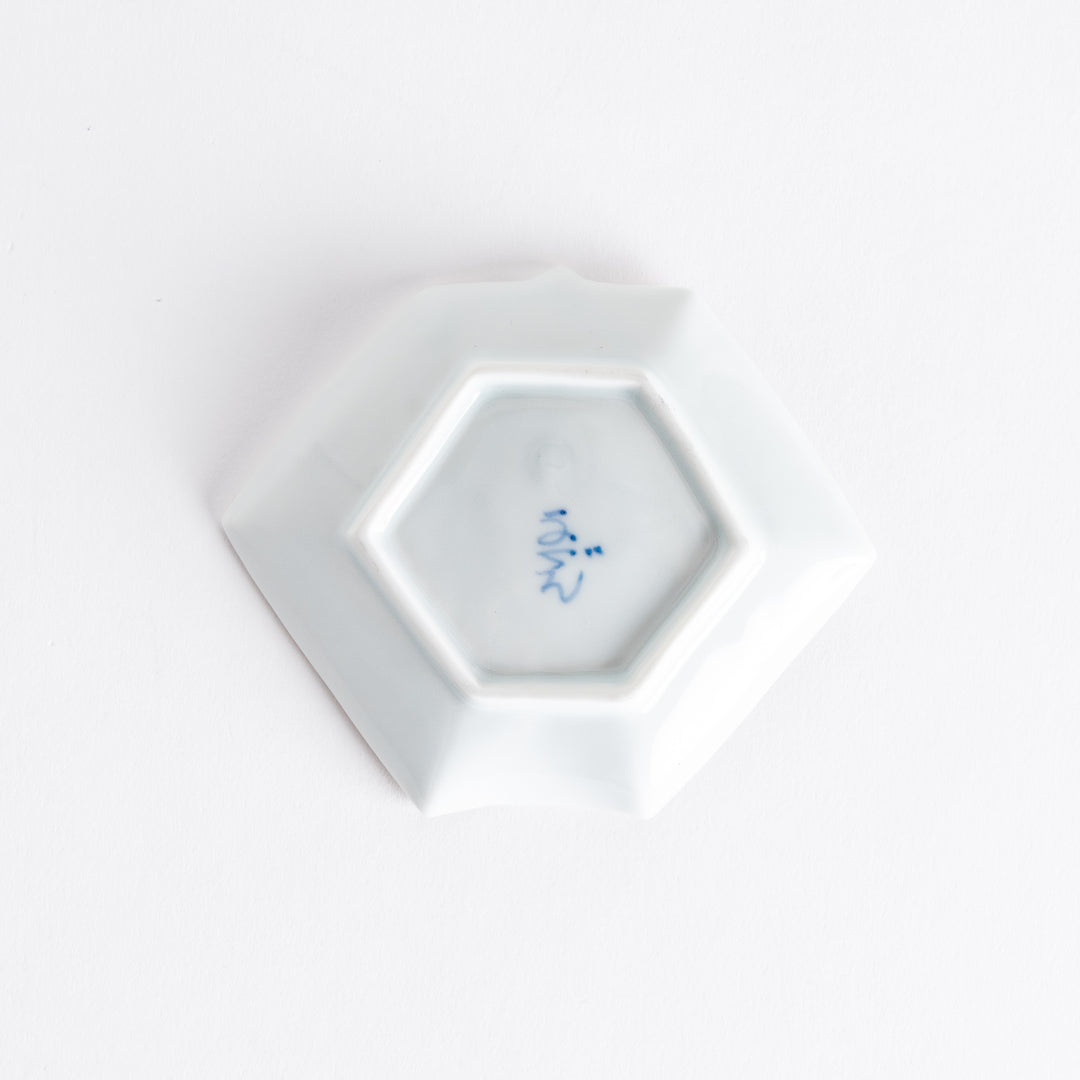 Bottom view of the Red Plum Origami Sauce Dish, showing the hexagonal base and a signature mark on the porcelain.