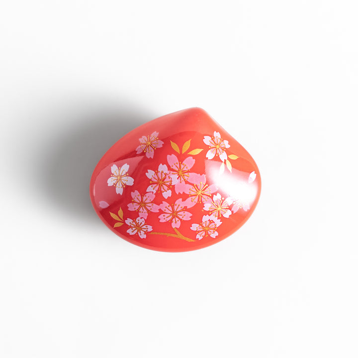 Red sakura shell incense holder with a floral lid and a white cherry blossom-shaped stand, designed to elegantly catch ash while enhancing any space.