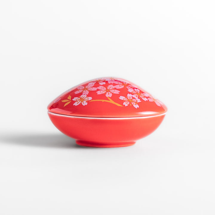 Red sakura shell incense holder with a floral lid and a white cherry blossom-shaped stand, designed to elegantly catch ash while enhancing any space.