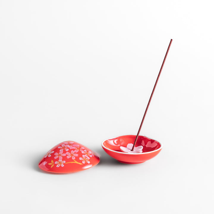 Red sakura shell incense holder with a floral lid and a white cherry blossom-shaped stand, designed to elegantly catch ash while enhancing any space.