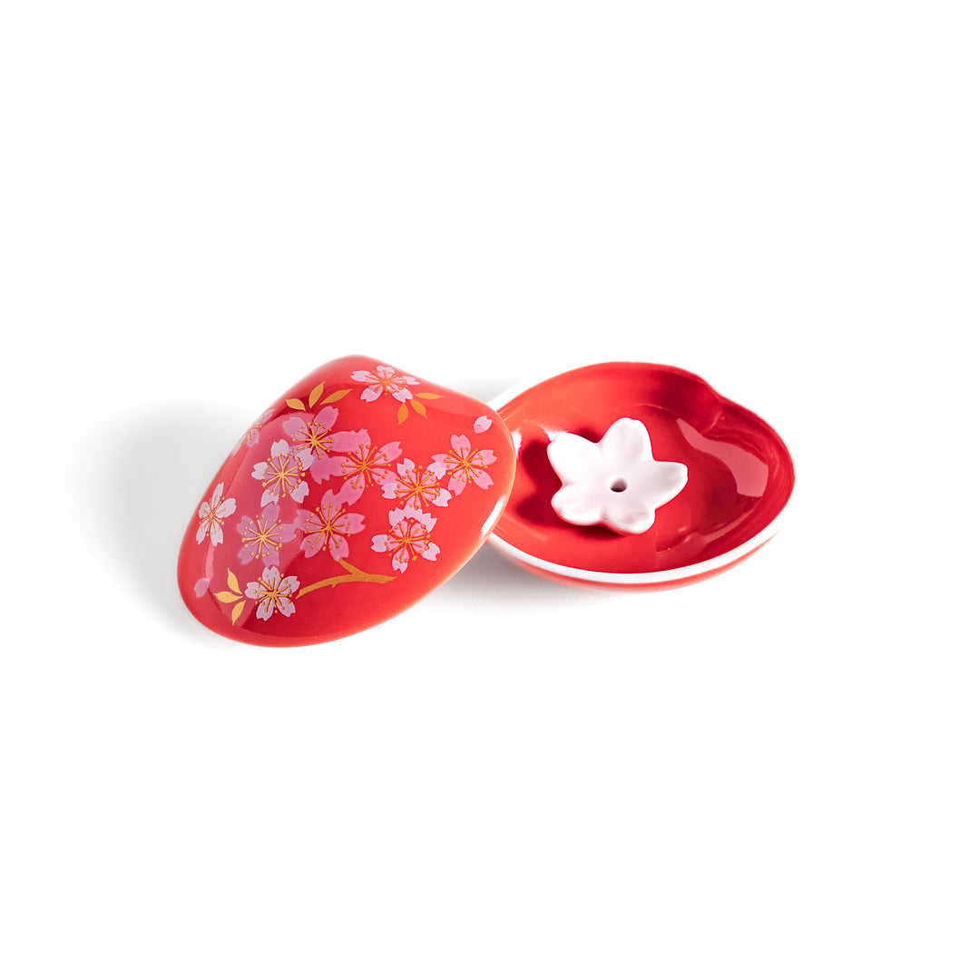 Red sakura shell incense holder with a floral lid and a white cherry blossom-shaped stand, designed to elegantly catch ash while enhancing any space.