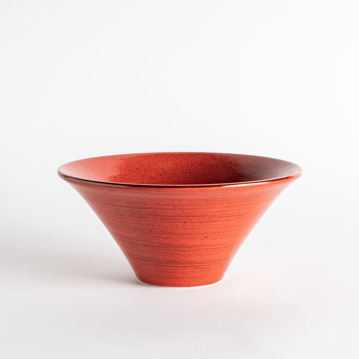 A red ramen bowl with black horizontal lines engraved around its exterior.