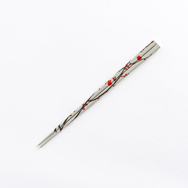 White chopstick with red plum blossom patterns, showcasing its traditional design.