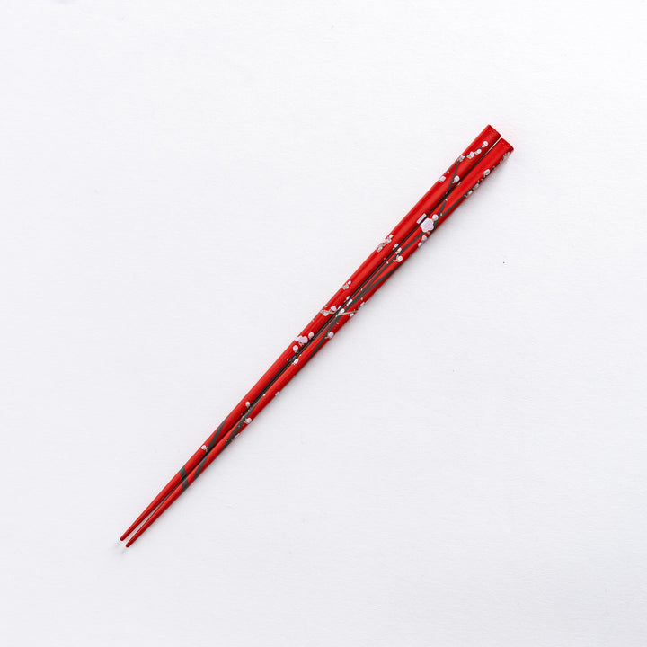 Red chopstick with white plum blossom patterns, showcasing its traditional design.