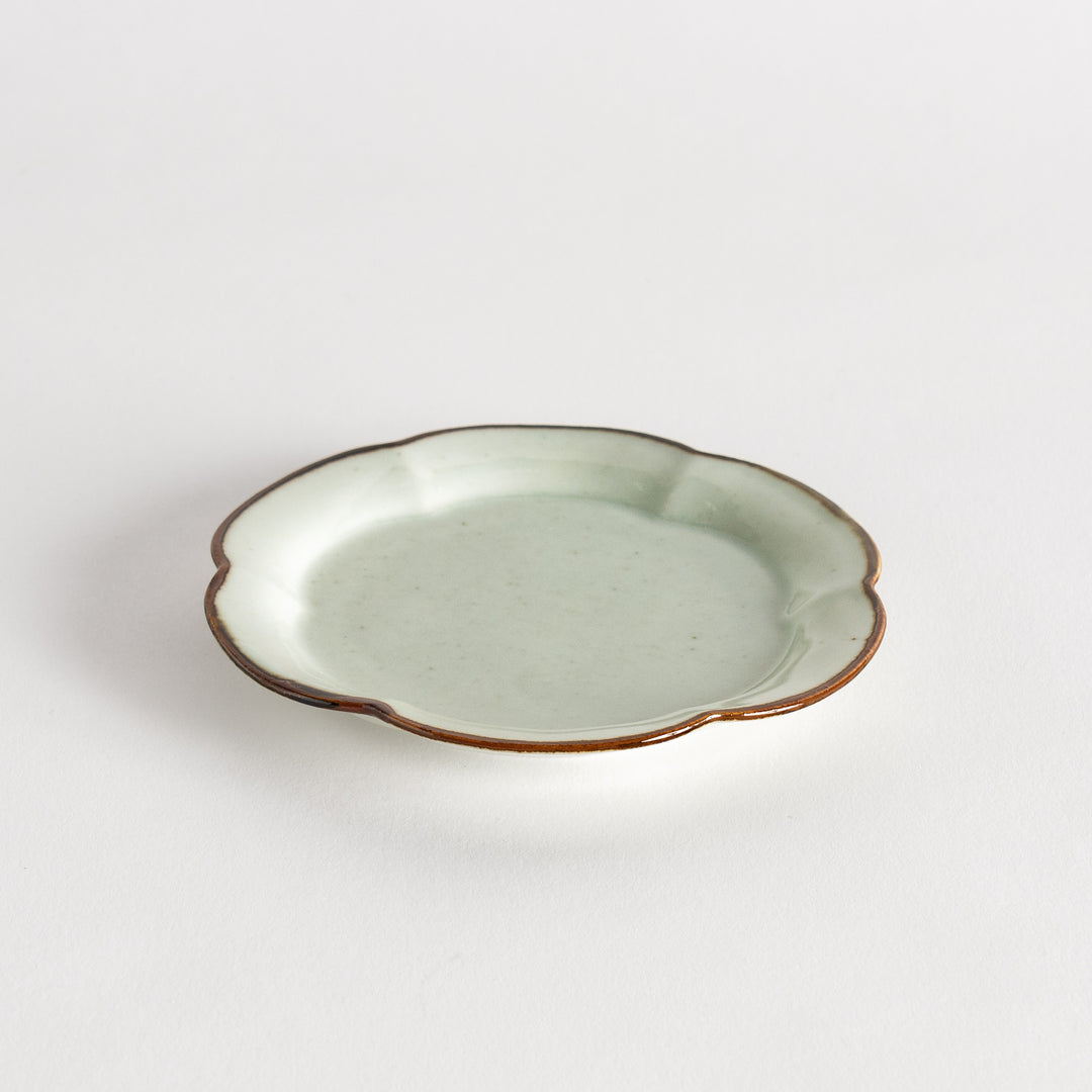 Small flower-shaped sauce dish in green, brown, and white.