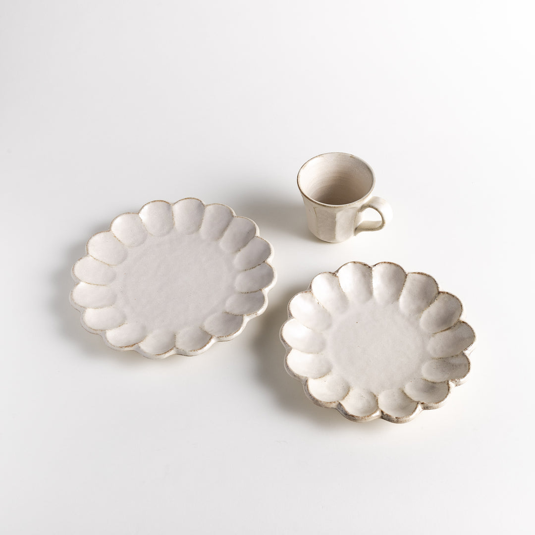 Three-piece Rinka Petal Set, featuring two plates with scalloped edges and a matching cup, all with a minimalist, natural design.