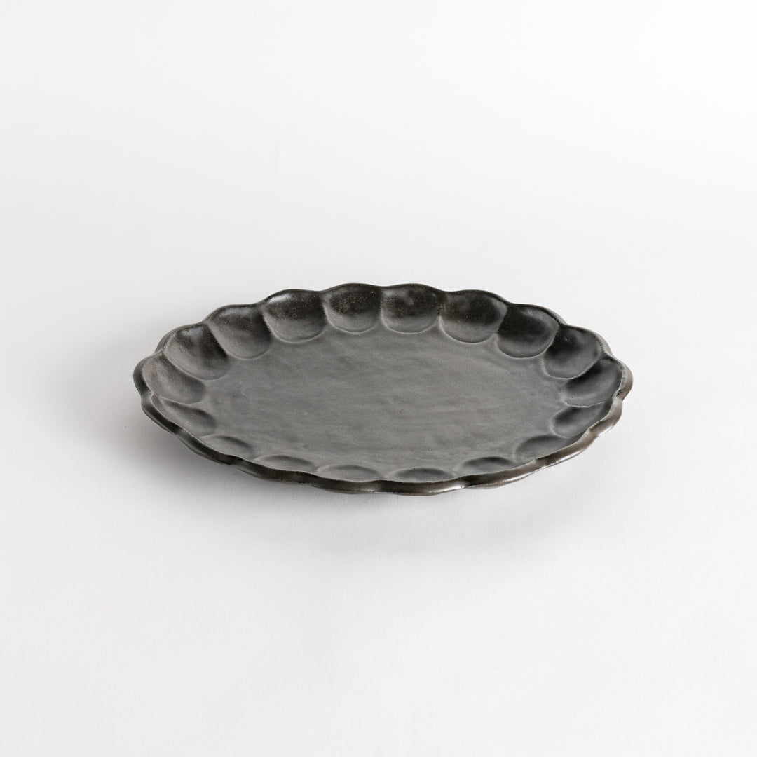 A white ceramic serving plate with a delicate, scalloped oval shape. Available in black or white.