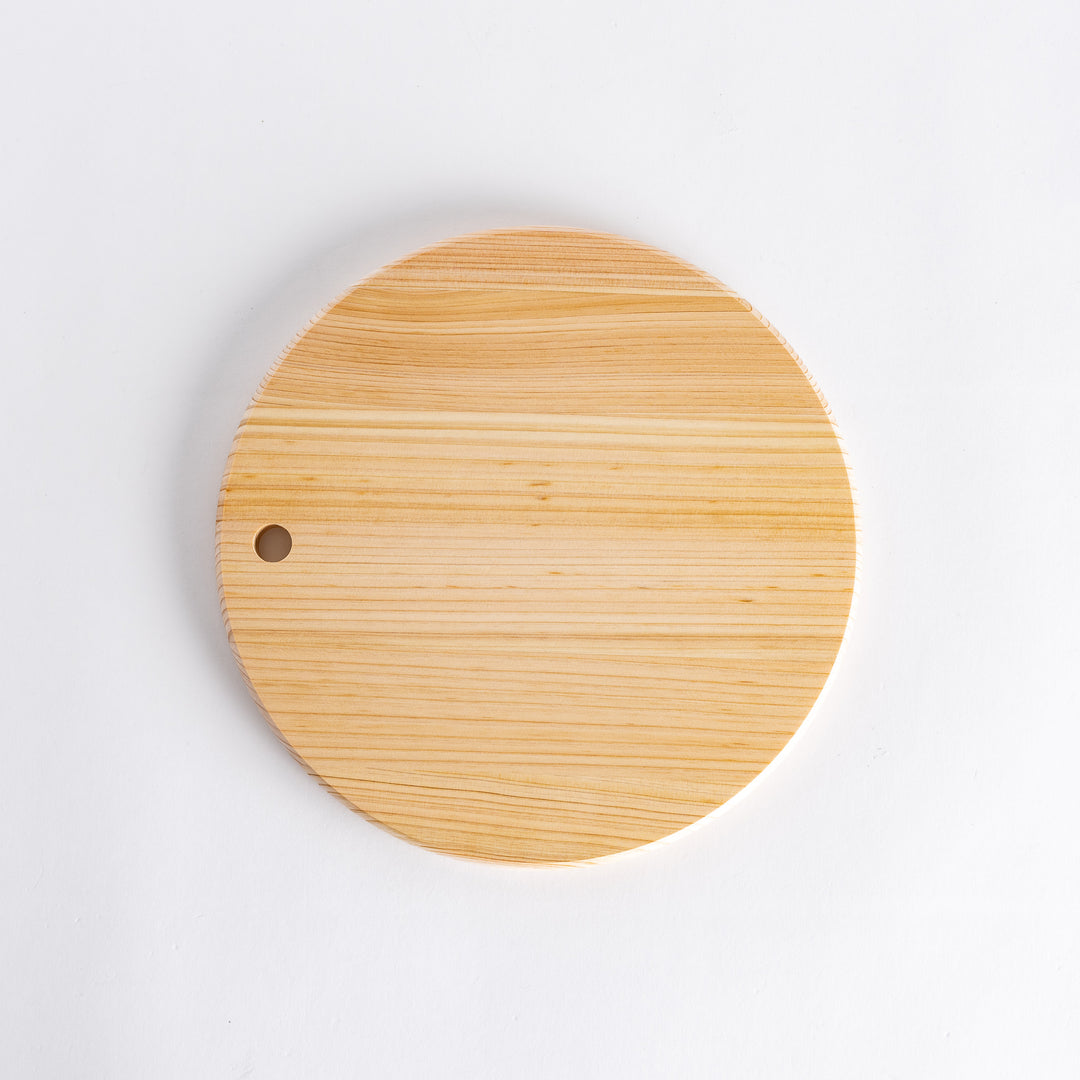 Round Hinoki cutting board with a hole for hanging.