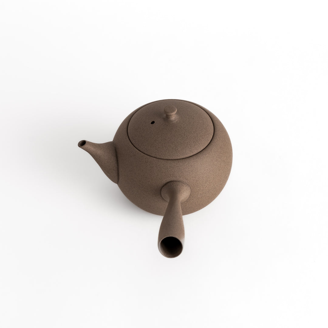 Angled view of the gray teapot highlighting its textured surface and smooth, rounded form.