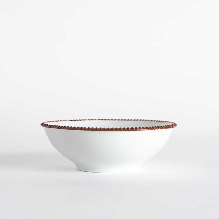 A round white cereal bowl with a rustic scallop-edged border. The border comes in blue, brown, and olive.