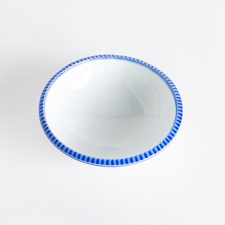 A round white dessert bowl with a rustic scallop-edged border. The border comes in blue, brown, and olive.