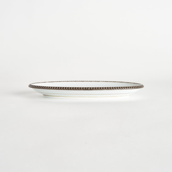 Side view of an oval salad plate with a subtle olive-colored scalloped edge.