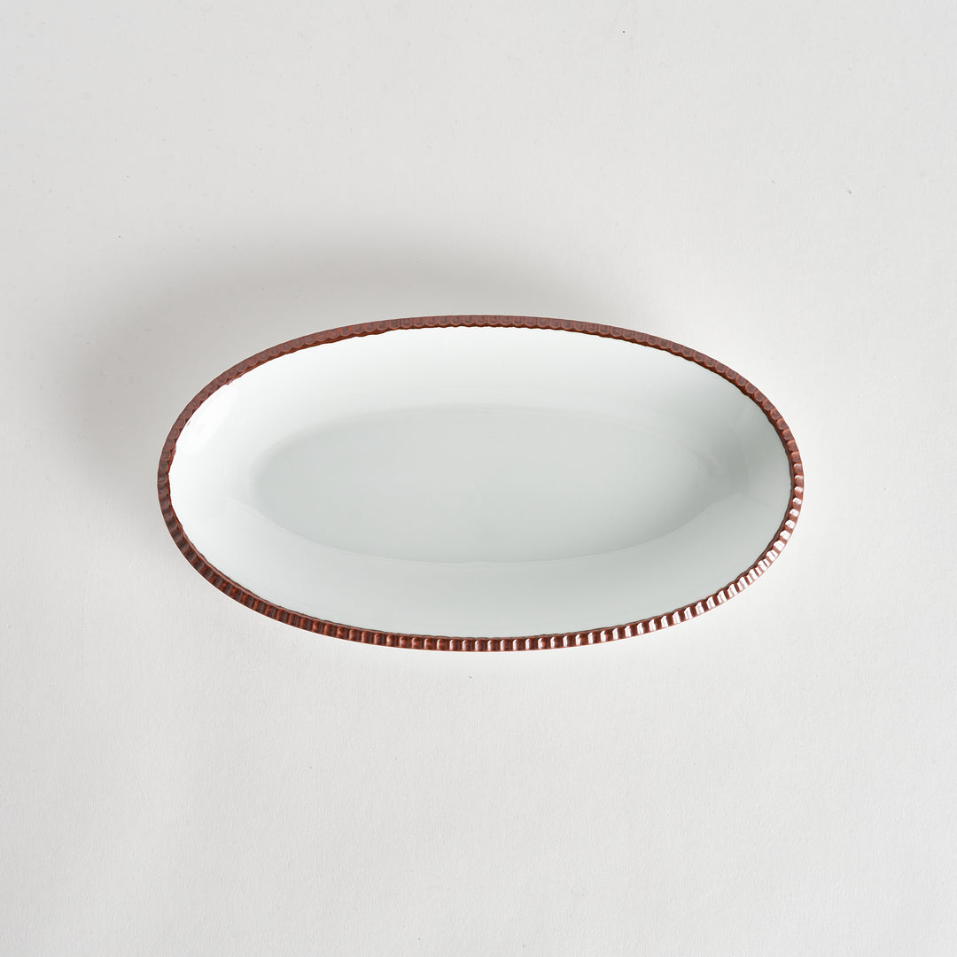 Top-down view of an oval salad platewith rustic scalloped edges and a brown-colored scalloped edge, showcasing its simple, elegant design.