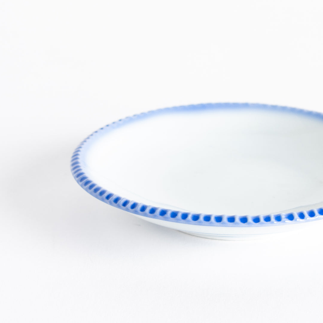 A round white sauce dish with a rustic scallop-edged border. The border comes in blue, brown, and olive.