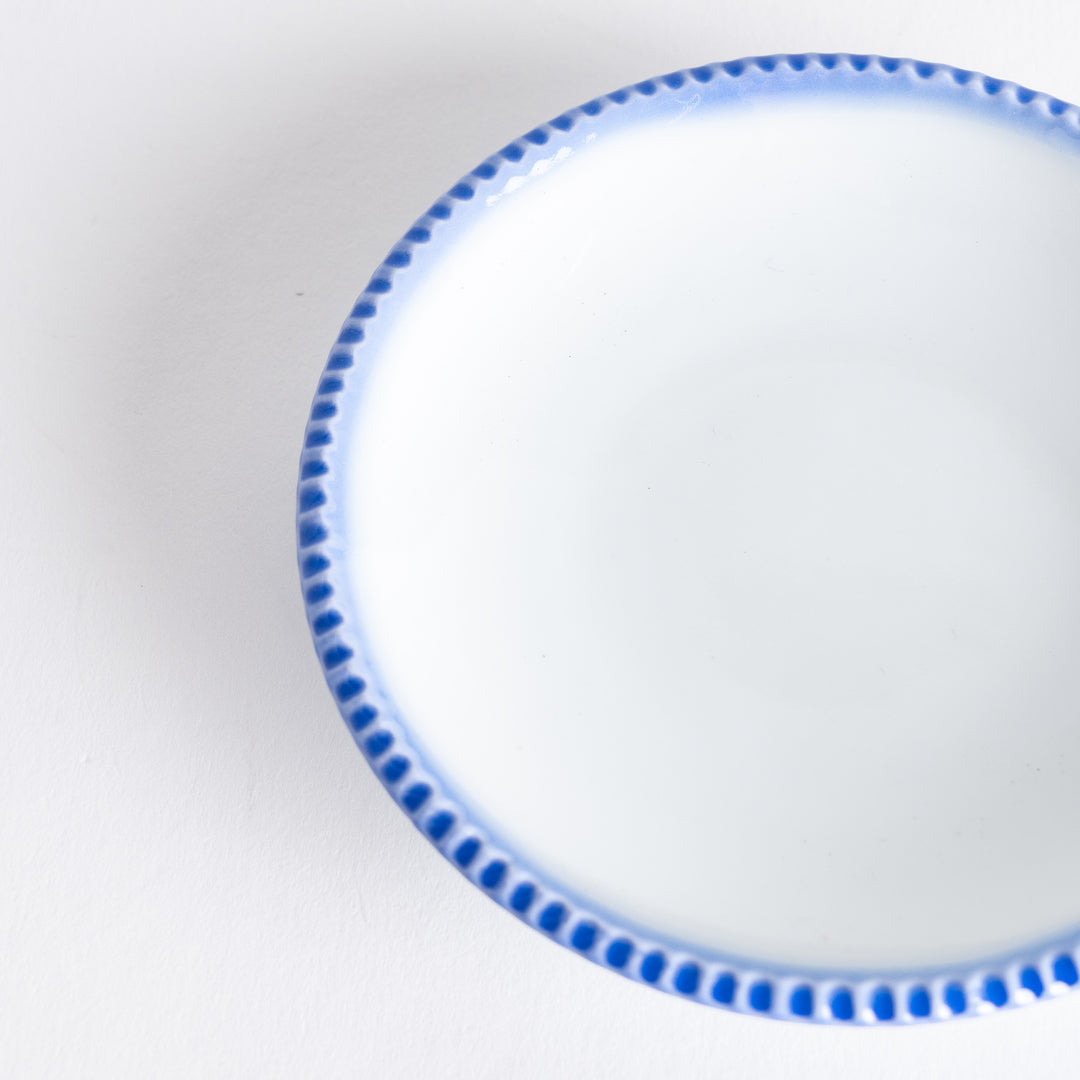 A round white sauce dish with a rustic scallop-edged border. The border comes in blue, brown, and olive.