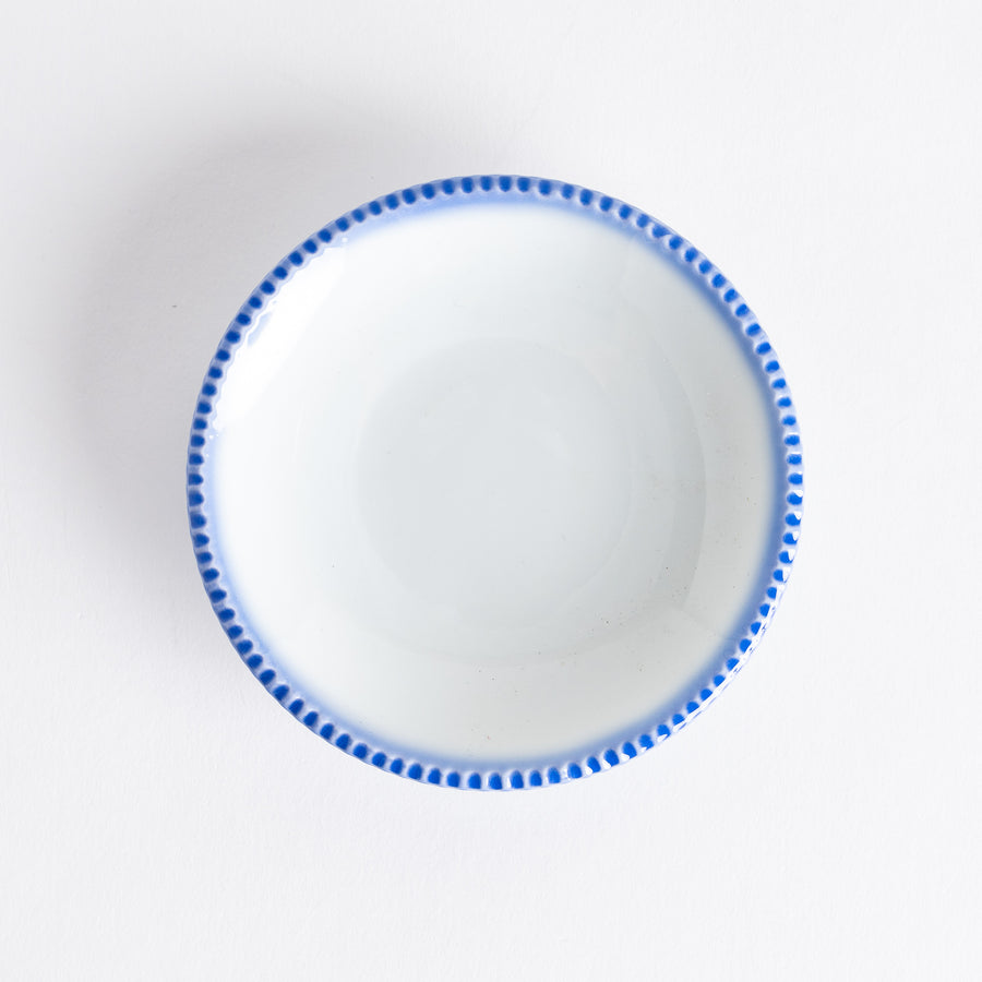 A round white sauce dish with a rustic scallop-edged border. The border comes in blue, brown, and olive.