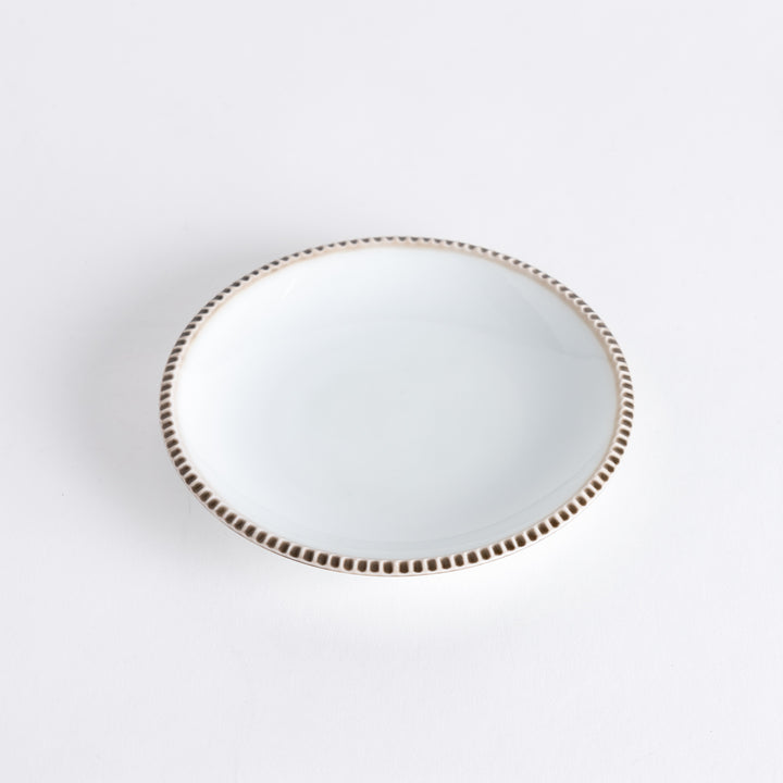 A round white dessert plate with a rustic scallop-edged border. The border comes in blue, brown, and olive.